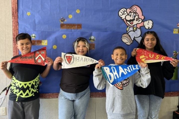4 students showing their dream school flag for college 
